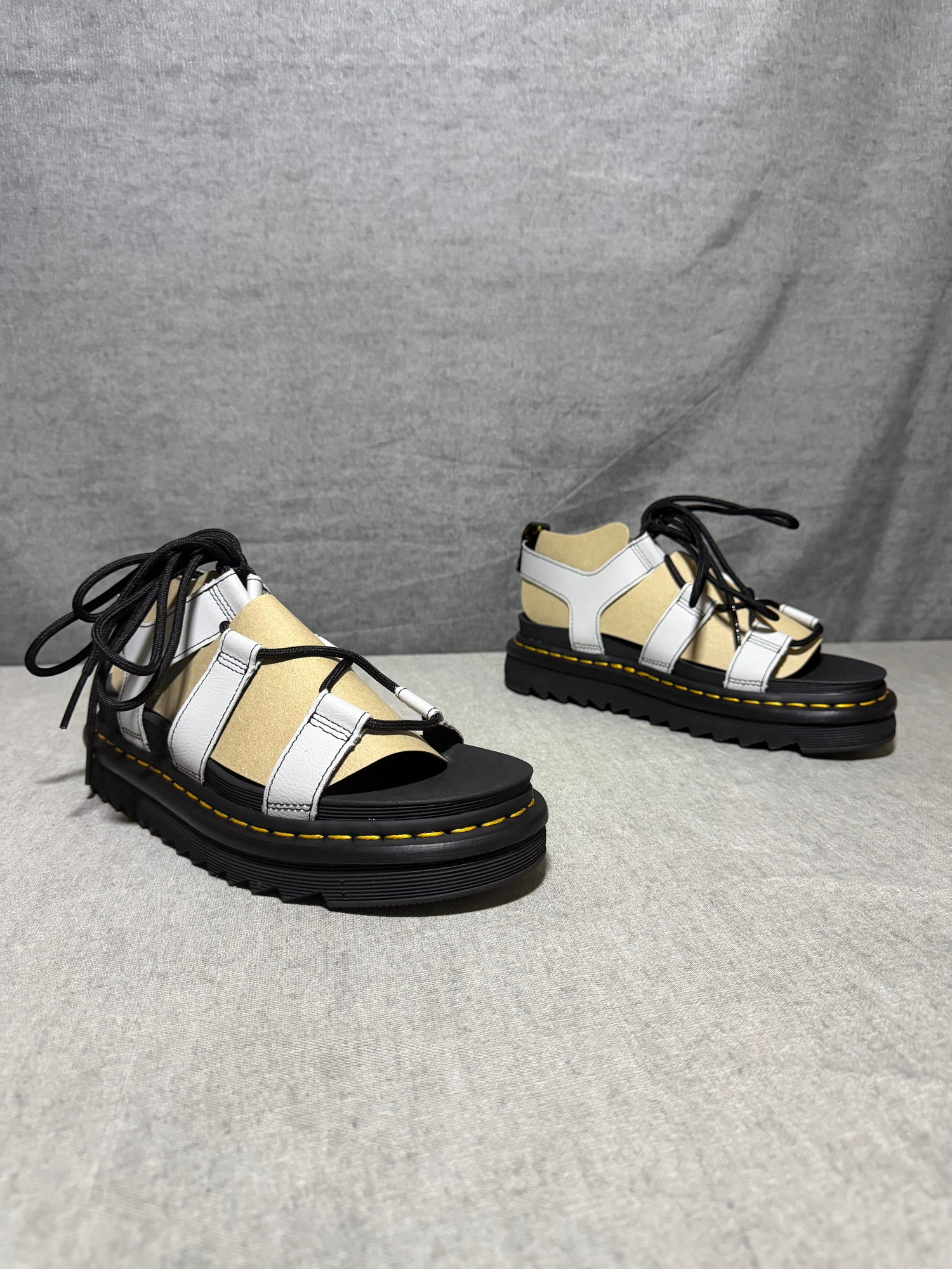 Dr. Martens Nartilla gladiator sandals in mist grey leather with black wraparound laces and a chunky platform sole.