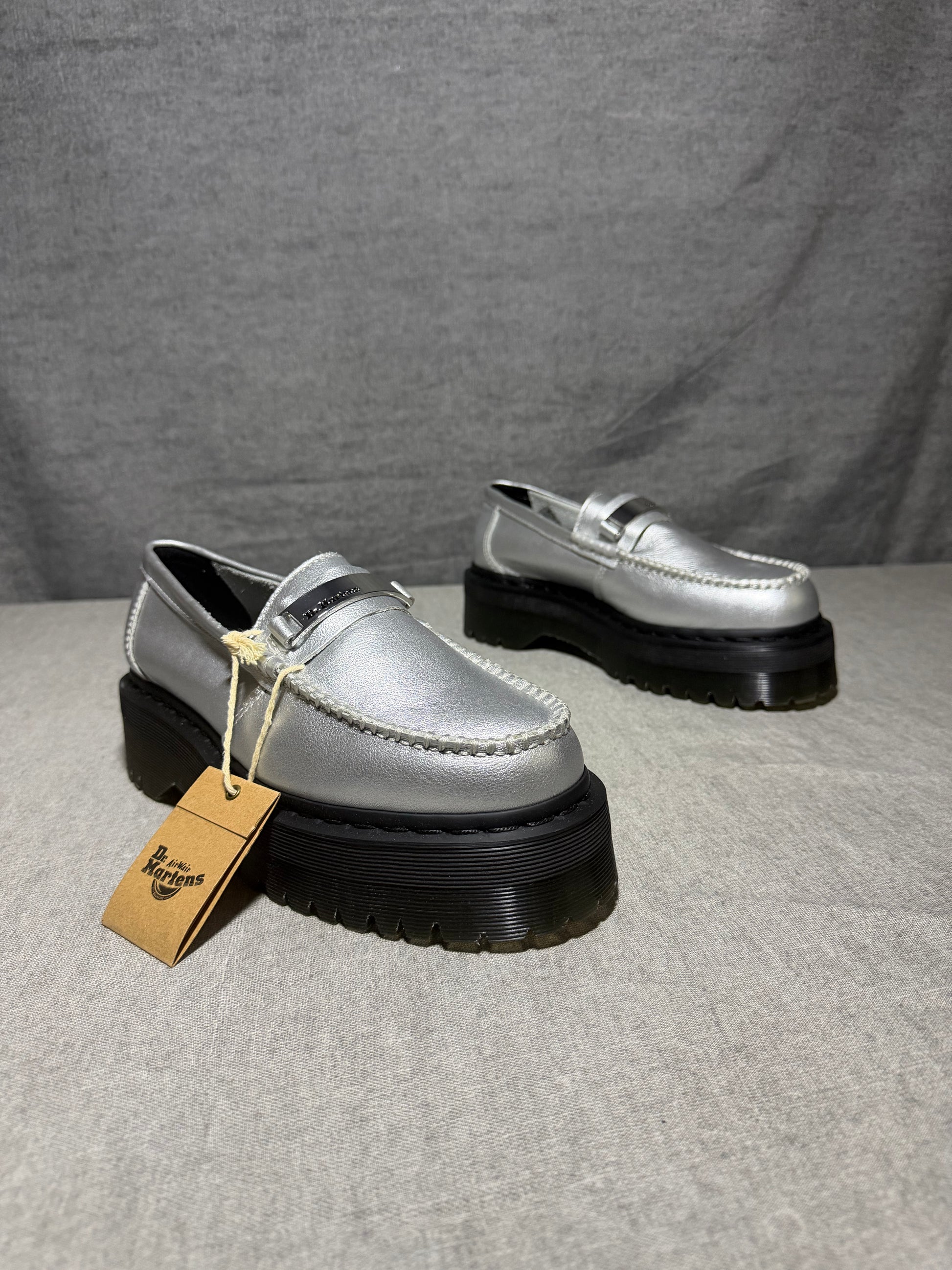 Dr. Martens Penton II Quad slip-on loafers in silver metallic pebbled leather with a chunky platform sole and metal logo plate.